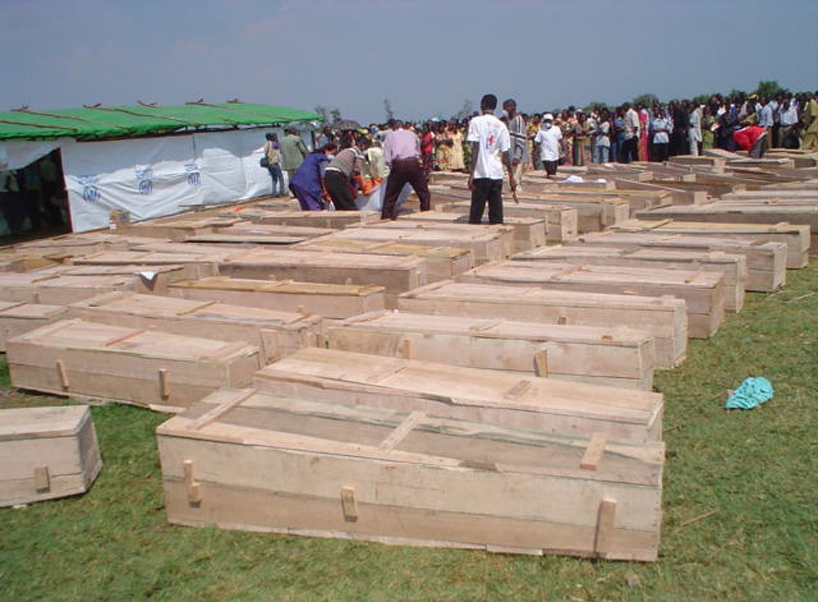 Coffins laid out near a UNHCR tent as survivors identify victims at Gatumba